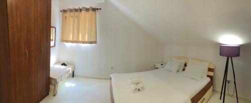 a white bedroom with a teddy bear sitting on a bed at Apartments Djurovic in Kotor