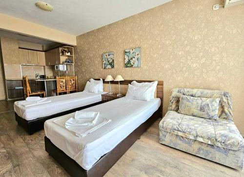 a hotel room with two beds and a couch at Villa Magnolia in Sozopol