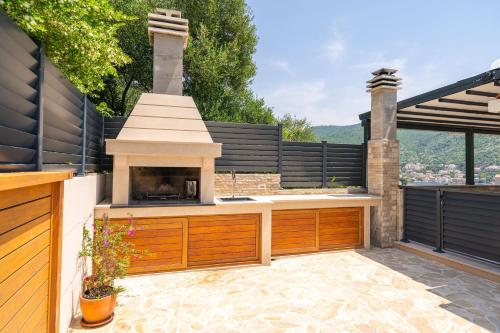 eine Außenküche mit Grill auf einer Terrasse in der Unterkunft Villa Tranquility Nest Beniva in Mokošica
