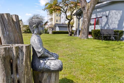 Eine Statue eines Mannes, der auf einem Zaun sitzt. in der Unterkunft Ferienwohnungen Haus Anna OFC 26 in Kühlungsborn