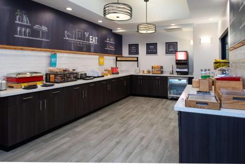 a large kitchen with wooden cabinets and a counter at Hampton Inn Kansas City Northeast in Kansas City