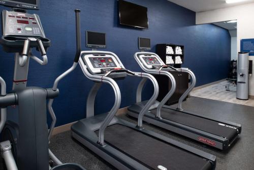a gym with three cardio machines in a room at Hampton Inn Kansas City Northeast in Kansas City