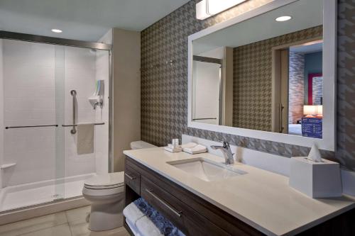 ein Badezimmer mit einem Waschbecken, einem WC und einem Spiegel in der Unterkunft Home2 Suites By Hilton Odessa in Odessa
