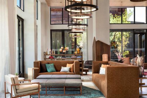 a living room with couches and chairs and windows at Canopy By Hilton Scottsdale Old Town in Scottsdale