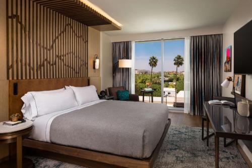 a hotel room with a bed and a large window at Canopy By Hilton Scottsdale Old Town in Scottsdale