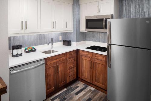 a kitchen with a stainless steel refrigerator and wooden cabinets at Homewood Suites by Hilton Boston Seaport District in Boston