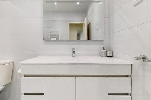 a white bathroom with a sink and a mirror at Heaven's House in Cascais