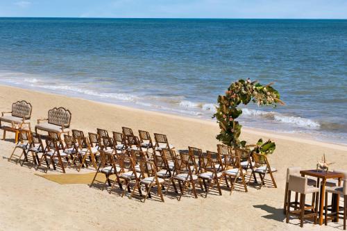 un grupo de sillas y mesas en una playa en Waldorf Astoria Cancun en Cancún