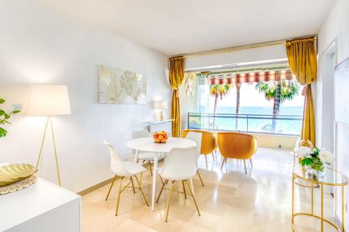 une salle à manger avec une table et des chaises blanches dans l'établissement C4 - 1 BDR Facing Sea & Beach - Parking, Tennis & Wifi, à Cannes