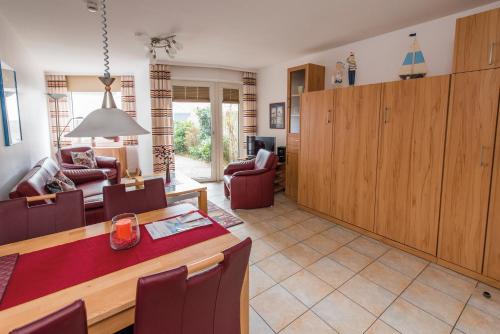 een keuken en een woonkamer met een tafel en stoelen bij Am Grooten Steen - Seehund in Cuxhaven