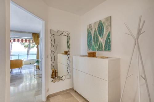 une chambre blanche avec une commode et un tableau sur le mur dans l'établissement C4 - 1 BDR Facing Sea & Beach - Parking, Tennis & Wifi, à Cannes