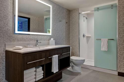 een badkamer met een wastafel, een toilet en een spiegel bij Home2 Suites By Hilton Barstow, Ca in Barstow