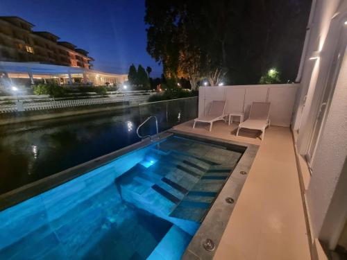 uma piscina à noite com duas cadeiras à volta em Estalagem Santa Iria Hotel & Spa em Tomar