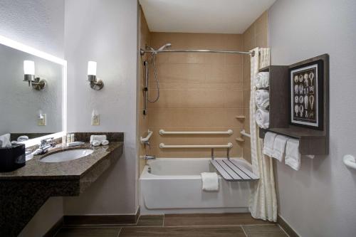 a bathroom with a tub and a sink and a shower at Homewood Suites Newport News - Yorktown by Hilton in Newport News