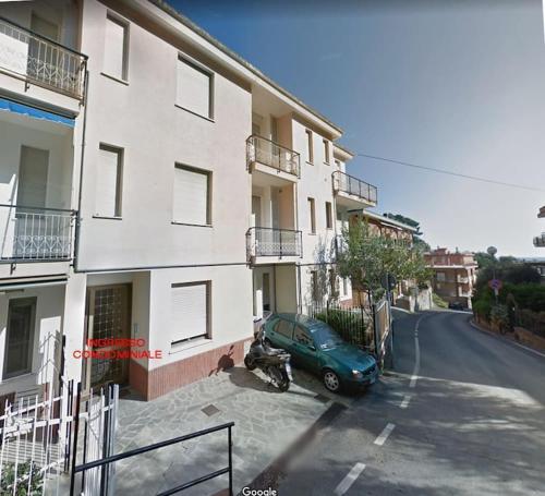 einem grünen Auto, das vor einem Gebäude parkt in der Unterkunft Monolocale n°5 vicino al centro e con dehor in Laigueglia