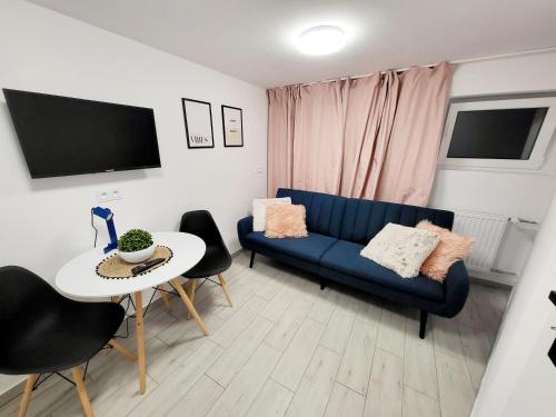 a living room with a blue couch and a table at Mini Apartamenty Poznań in Poznań