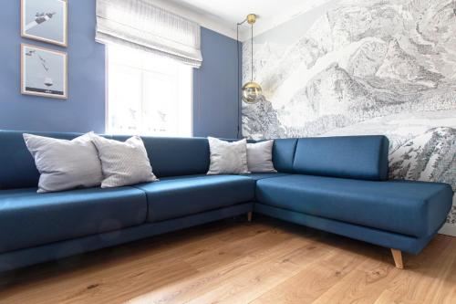 Sofá azul en la sala de estar con cama en Ferienhaus im Altstadtgässchen mit 3 Badezimmern, en Quedlinburg