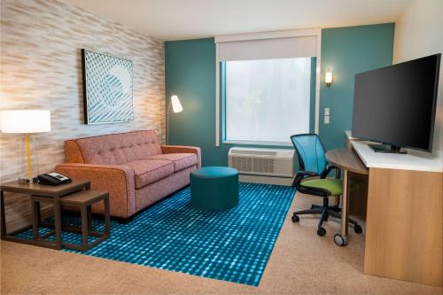 a living room with a couch and a desk with a computer at Home2 Suites Corona, Ca in Corona