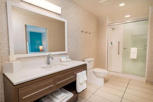 a bathroom with a sink and a toilet and a mirror at Home2 Suites Corona, Ca in Corona