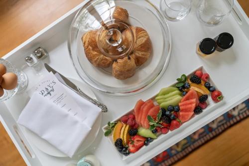 a table topped with a plate of fruit and pastries at The CAPE in Picton