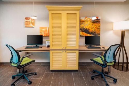 an office with a yellow cabinet and two desks with chairs at Home2 Suites Corona, Ca in Corona