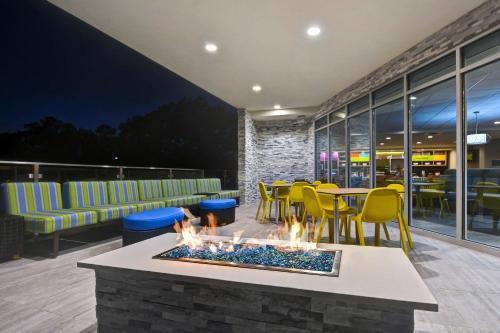 a fire pit in a restaurant with chairs and tables at Home2 Suites By Hilton Savannah Midtown, Ga in Savannah