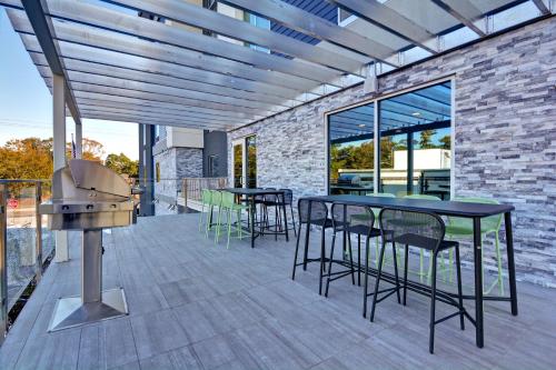 a patio with tables and chairs and a grill at Home2 Suites By Hilton Savannah Midtown, Ga in Savannah