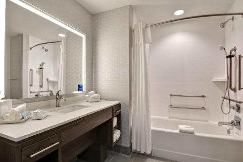 a bathroom with a sink and a tub and a shower at Home2 Suites By Hilton Savannah Midtown, Ga in Savannah