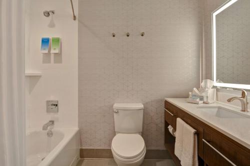 a bathroom with a toilet and a tub and a sink at Home2 Suites By Hilton Savannah Midtown, Ga in Savannah