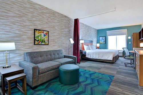 サバンナにあるHome2 Suites By Hilton Savannah Midtown, Gaのソファとベッド付きのホテルルーム