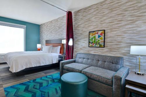 a hotel room with a bed and a couch at Home2 Suites By Hilton Savannah Midtown, Ga in Savannah