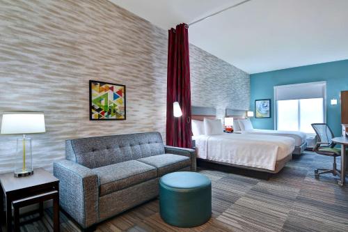 a hotel room with a bed and a couch at Home2 Suites By Hilton Savannah Midtown, Ga in Savannah