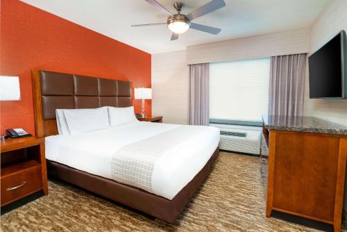 a hotel room with a bed and a flat screen tv at Homewood Suites by Hilton Baltimore - Arundel Mills in Hanover