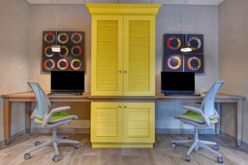 a yellow office with two desks and two chairs at Home2 Suites By Hilton Savannah Midtown, Ga in Savannah