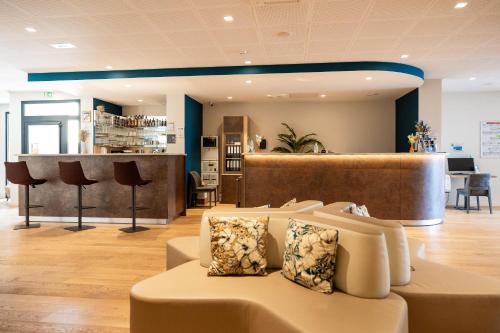 a lobby with a couch and a bar at Hôtel Le Bastia in Bastia