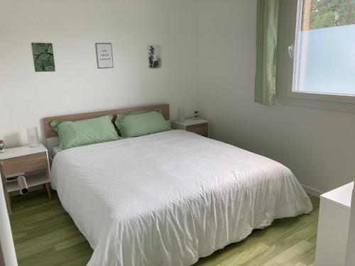 蓬迪卡斯的住宿－Au gîte d'Artigues，一间卧室配有一张带白色床单的床和一扇窗户。