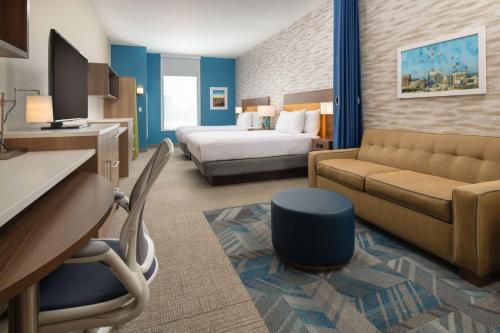 a hotel room with a bed and a couch at Home2 Suites By Hilton Boise Downtown in Boise