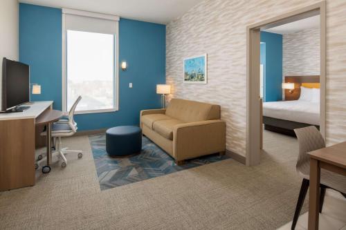 a hotel room with a bed and a desk and a chair at Home2 Suites By Hilton Boise Downtown in Boise