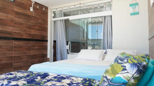 Schlafzimmer mit einem Bett und einem Fenster in der Unterkunft Suit's Bella Vista Arraial do Cabo in Arraial do Cabo