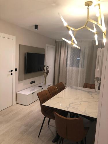 une salle à manger avec une table et des chaises et une télévision dans l'établissement Lina, à Nice