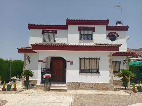 une petite maison blanche avec un toit rouge dans l'établissement El rincón de Dory, à Martos