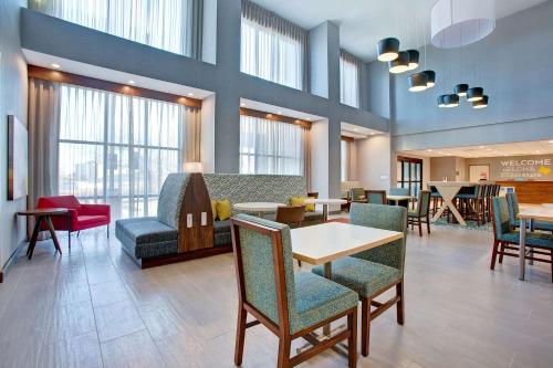 a waiting room with tables and chairs and windows at Hampton Inn & Suites Borger in Borger