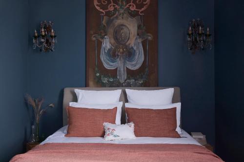 a blue bedroom with a bed with two pillows at Maisons 322 - Maison L'Insolite in Le Bois-Plage-en-Ré