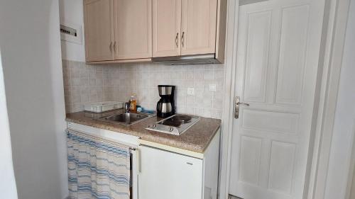 a small kitchen with a sink and a counter at Olympic Villas in Oia