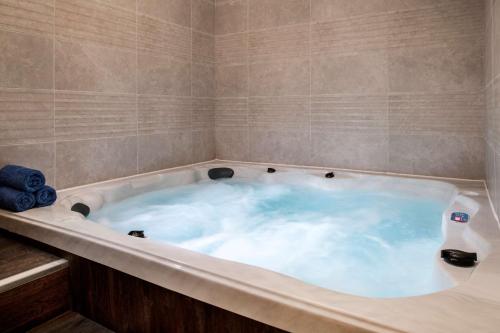 a jacuzzi tub with blue water in it at DoubleTree Suites by Hilton - Riyadh Financial District in Riyadh