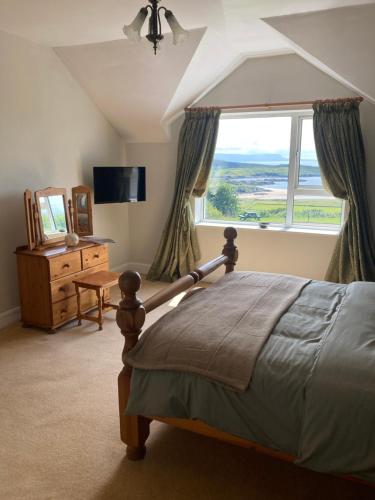 a bedroom with a bed and a large window at Millfarm House in Killybegs