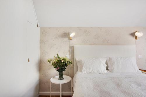 a bedroom with a bed with a vase of flowers on a table at Apartamento T1 - Salina Ria in Aveiro