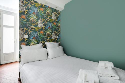 - une chambre avec un grand lit et du papier peint floral dans l'établissement Pick A Flat's Apartment in Montorgueil - Rue Léopold Bellan, à Paris