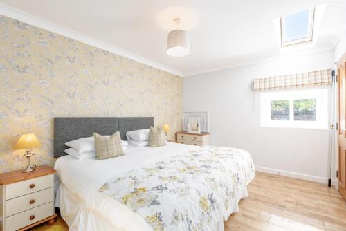 a bedroom with a large white bed and a window at Barn Cottage 2 bedroom with gorgeous views in Dunblane