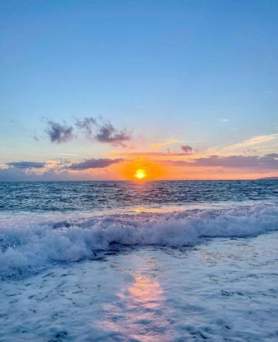 a sunset over the ocean with the waves at Hotel San Gaetano in Grisolia